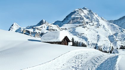 Mürren, schneebedeckte Alphütte mit Bergpanorama